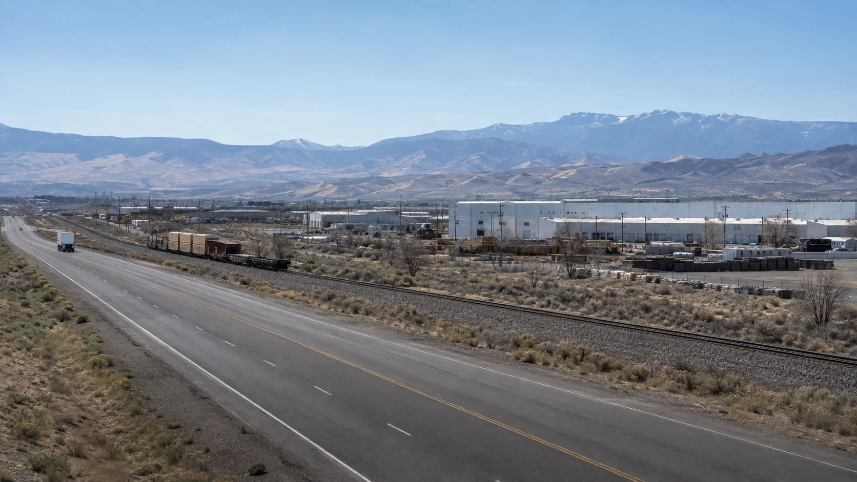 Industrial road and rail corridor in the Reno area with mountain ridges beyond